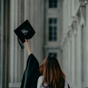 Graduanda con toga frente a un edificio universitario