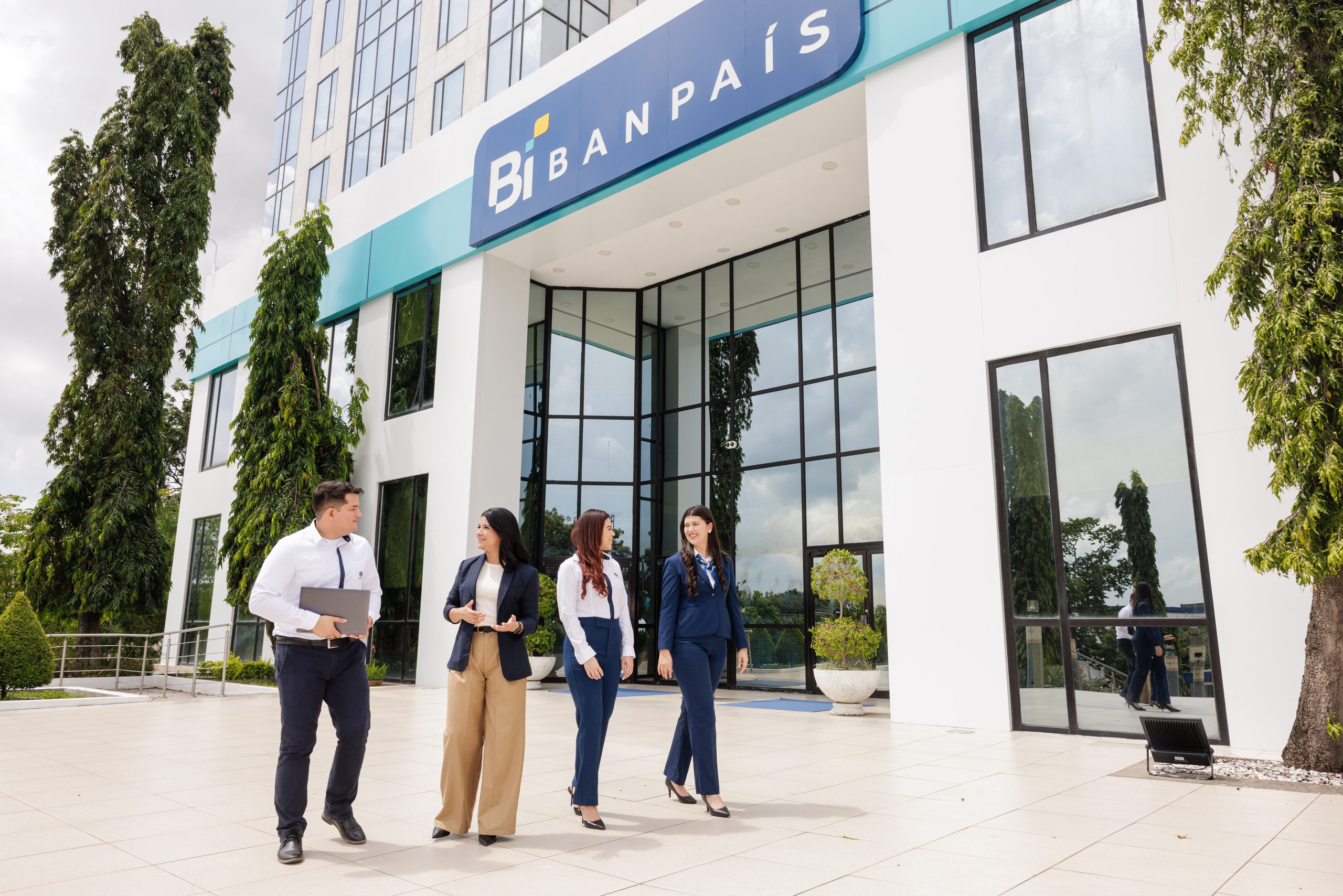Colaboradores de Banpaís saliendo de la agencia bajo el rótulo Bi BANPAÍS