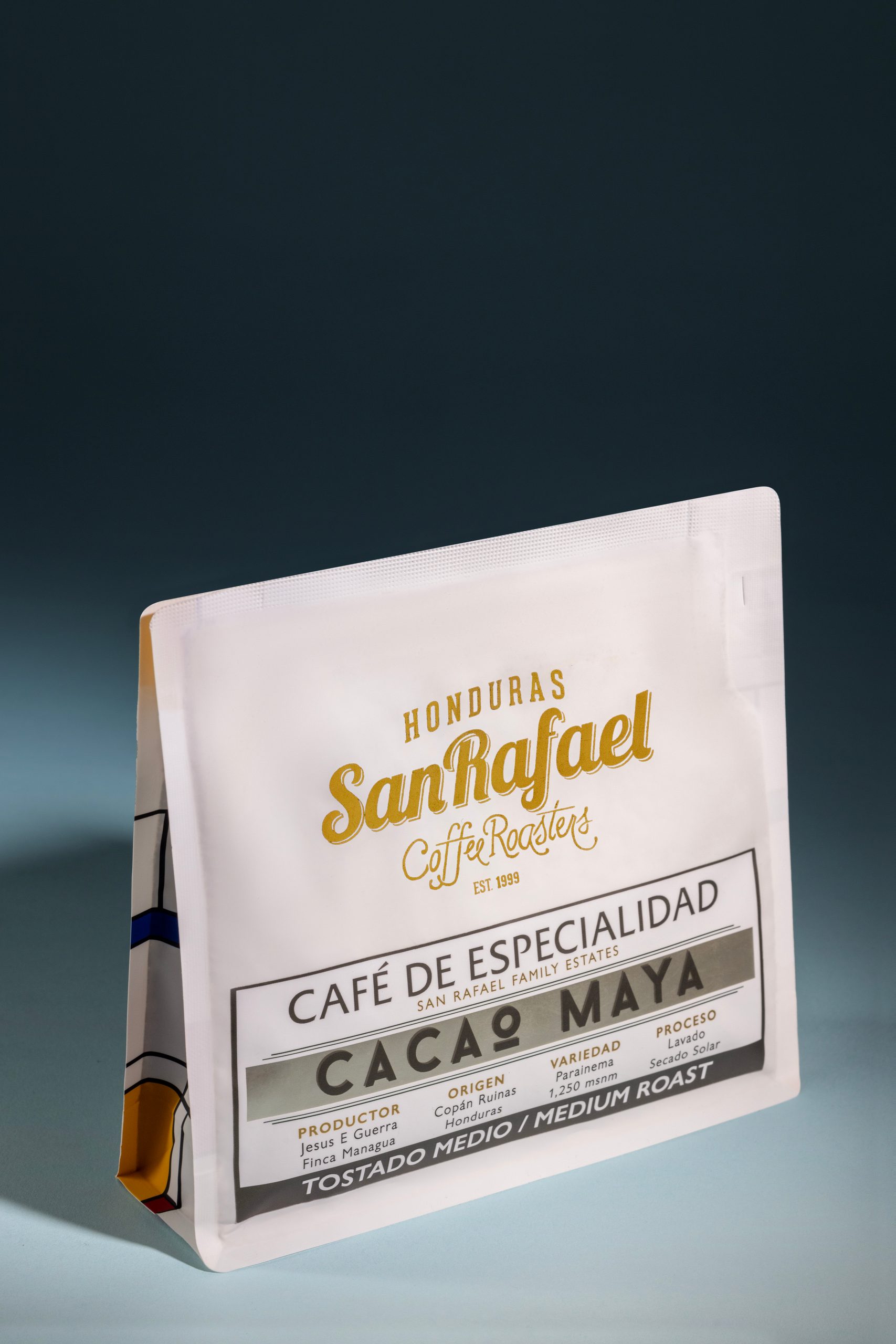 Bolsa blanca de café Cacao Maya de Café San Rafael sobre fondo oscuro