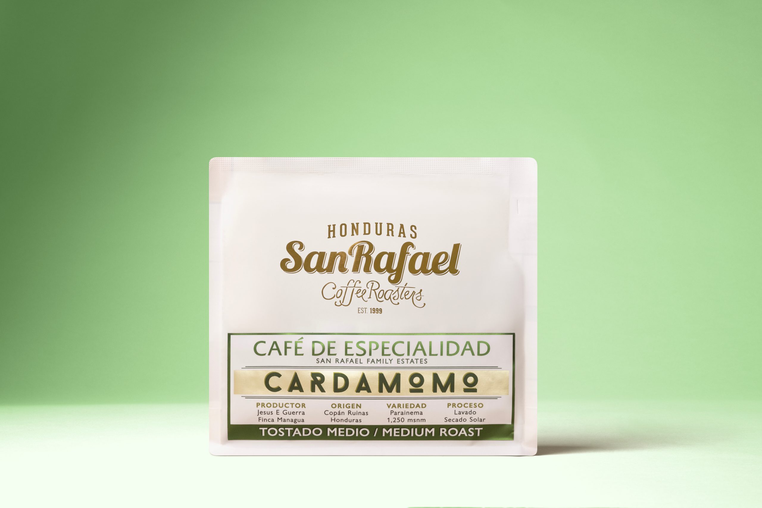 Bolsa blanca de café Cardamomo de Café San Rafael sobre fondo verde