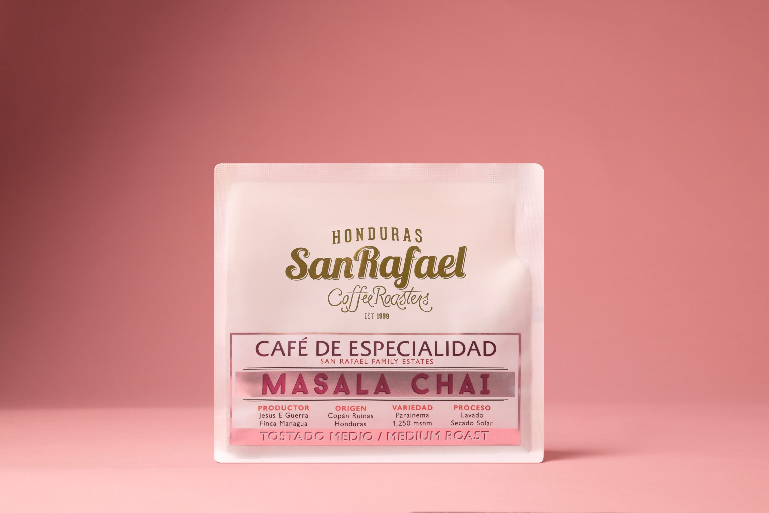 Bolsa blanca de café Masala Chai de Café San Rafael sobre fondo rosa