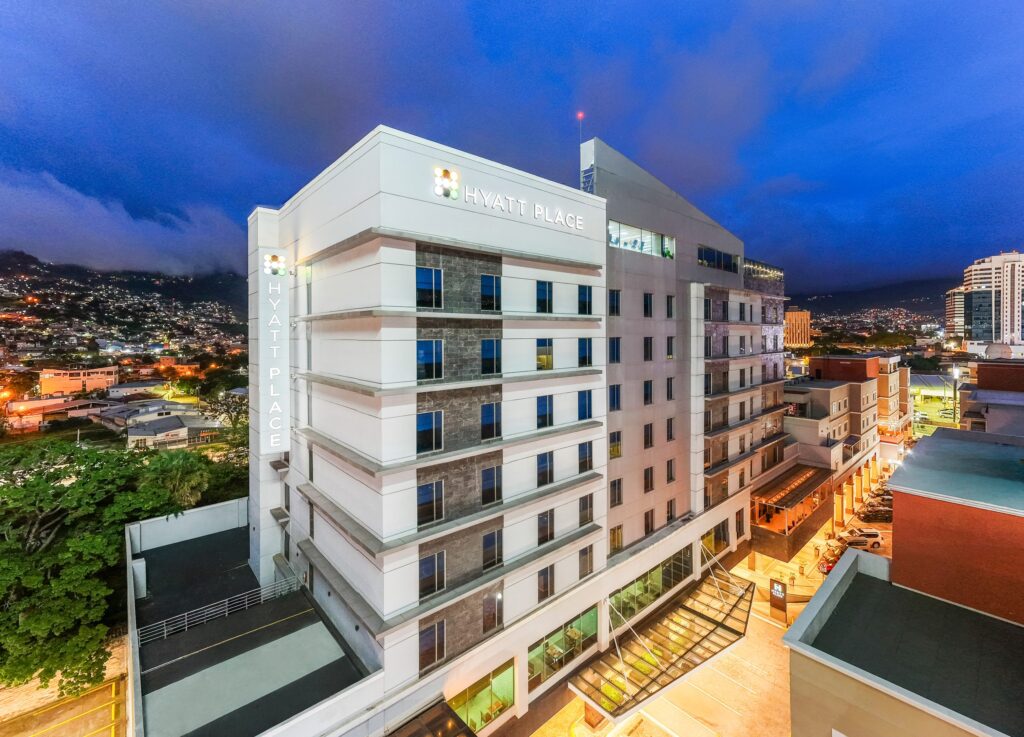 Vista aérea del Hyatt Place Tegucigalpa al anochecer con la ciudad iluminada