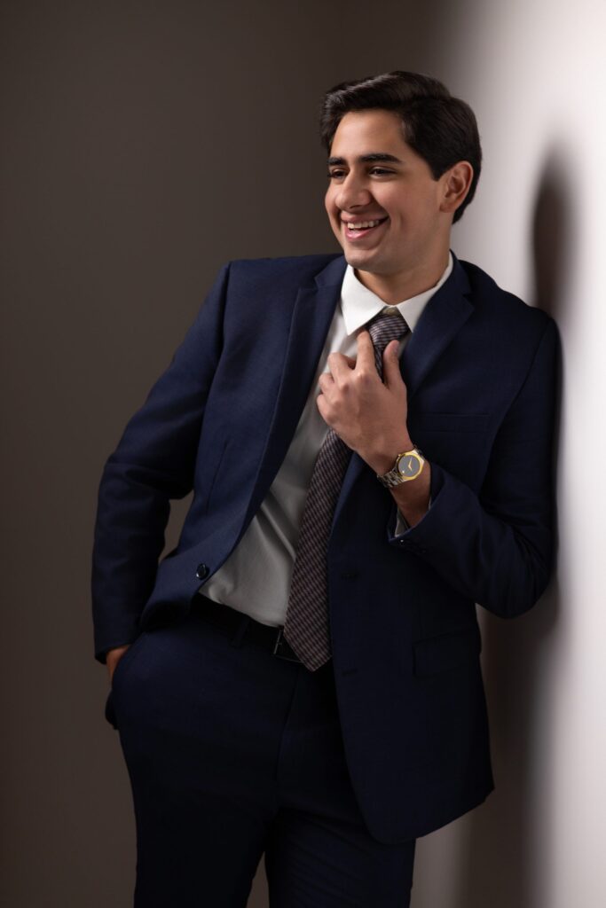 Fouad con traje azul apoyado en la pared, retrato senior formal, San Pedro Sula
